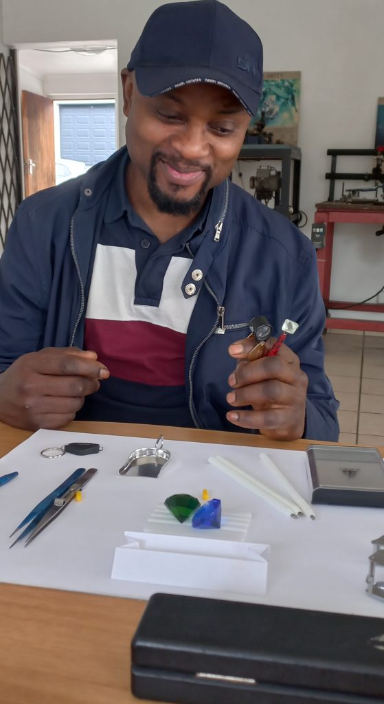 person-holding-loupe-inspecting-stones